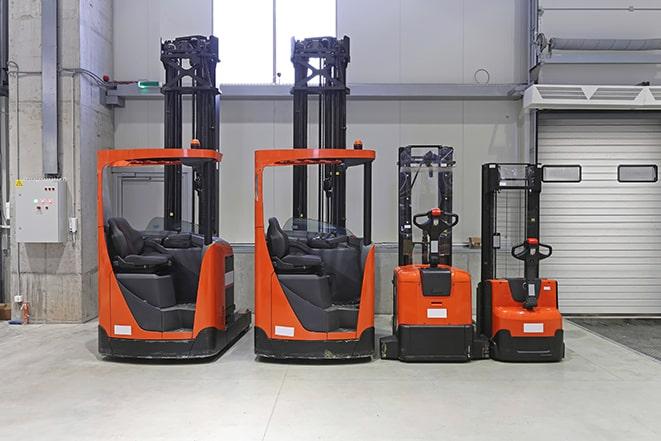 workers using forklifts to transport materials in a factory